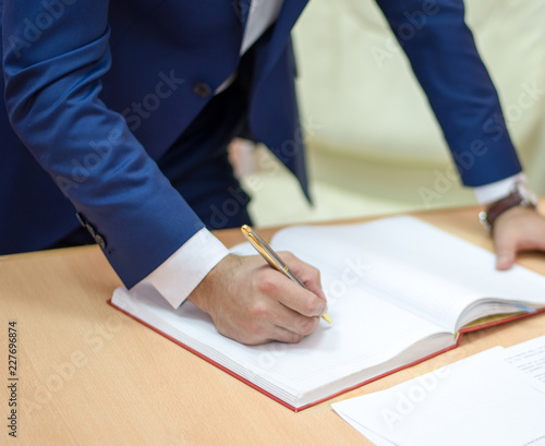 man signs the documents, the man signed a contract