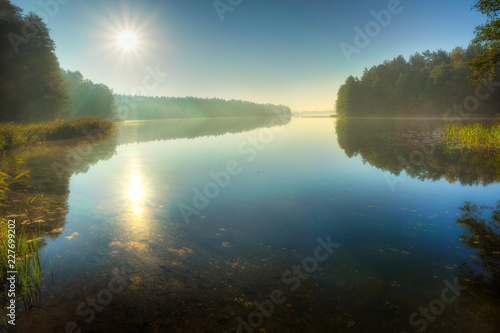 The sun illuminates the surface of the lake. Masuria, Poland.