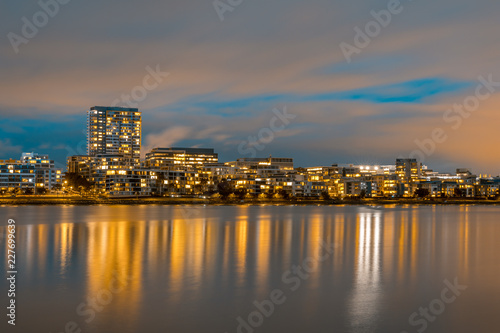 Modern apartments in a medium density suburb along the river. Reflections in the water. Dusk sky. Long exposure