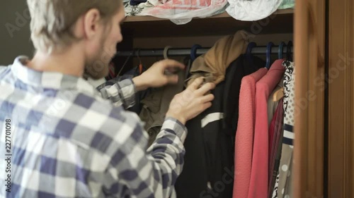 young frustrated teenager searching for a suitable clothes at home