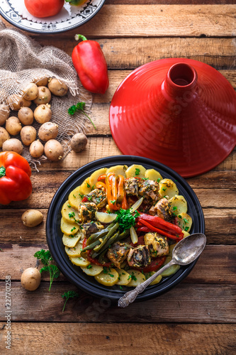 Fish tajine mqualli with potato and bell peppers, top view photo