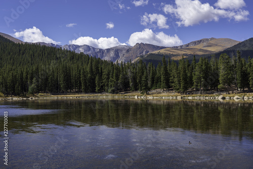 A fall view of a calm alpine lake with Mt. Evans in the background.