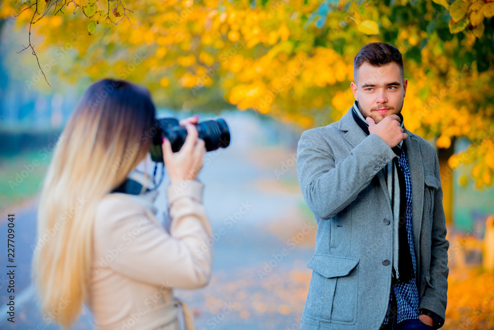 Young photographer with camera and model in autumn season outdoor. Young photographer with camera and model in autumn season outdoor.