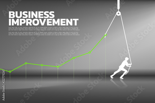 Silhouette of businessman pull up the business graph with rope and reel. concept of business improvement.
