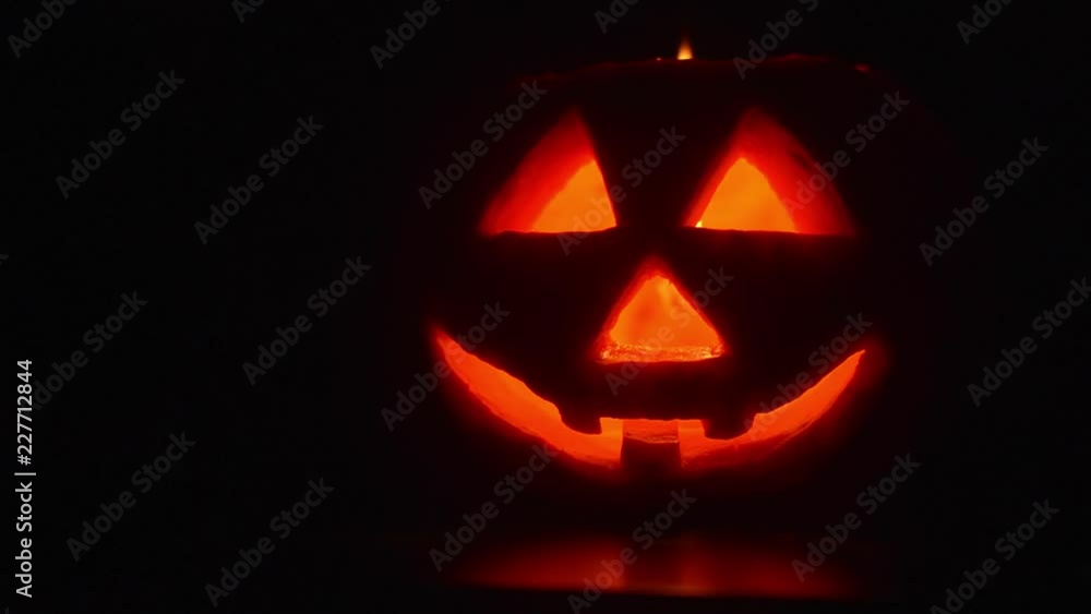 Someone is blowing a burning candle inside a Halloween pumpkin. Someone is blowing a burning candle inside a Halloween pumpkin.