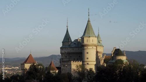 Romantic Bojnice medieval castle in Slovakia in sunset light, pan shot photo