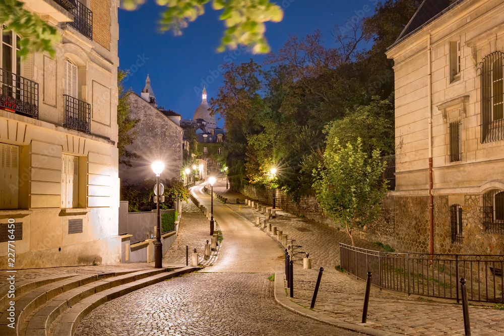 Empty cozy street and the Sacre-Coeur Basilica during morning blue hour, quarter Montmartre in Paris, France