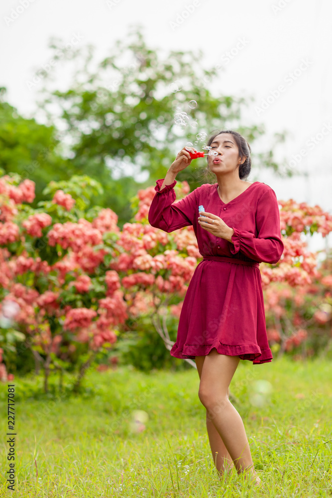 young asian woman with Carmen red dress blowing bubble young asian woman with Carmen red dress blowing bubble