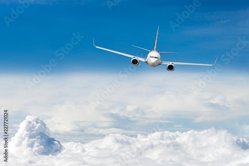 Biały samolot leci ponad chmurą