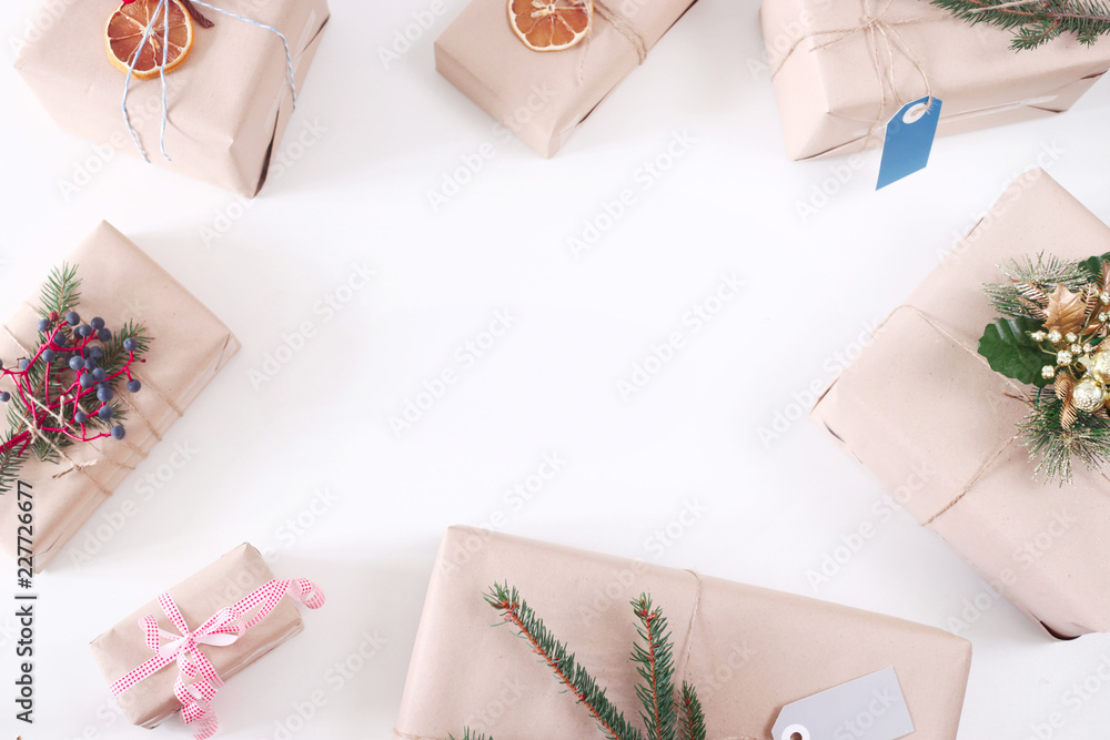 Christmas and New Year's gifts in craft paper decorated with fir branches, viburnum, oranges on a white background. Top view, flat lay. Copy space Christmas and New Year's gifts in craft paper decorated with fir branches, viburnum, oranges on a white background. Top view, flat lay. Copy space