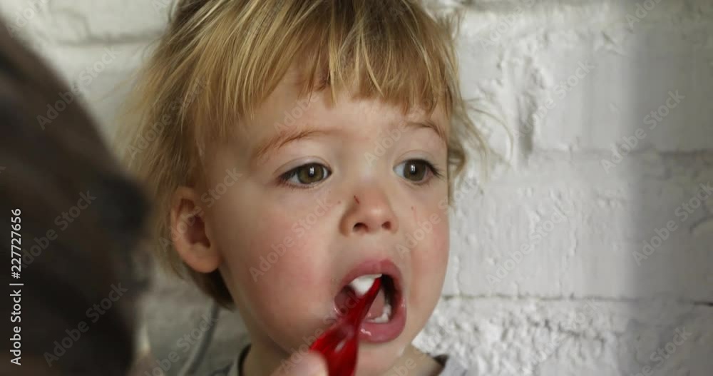 Child is brushing his teeth. Parent brushes his baby boy teeth in the bathroom Close up portrait Child is brushing his teeth. Parent brushes his baby boy teeth in the bathroom Close up portrait