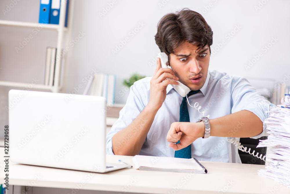 Overloaded busy employee with too much work and paperwork Overloaded busy employee with too much work and paperwork