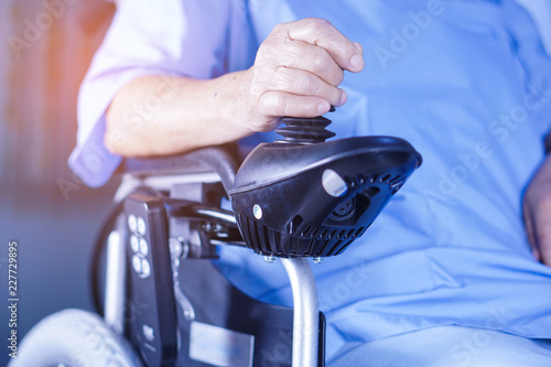 Asian senior or elderly old lady woman patient on electric wheelchair with remote control at nursing hospital ward : healthy strong medical concept  photo