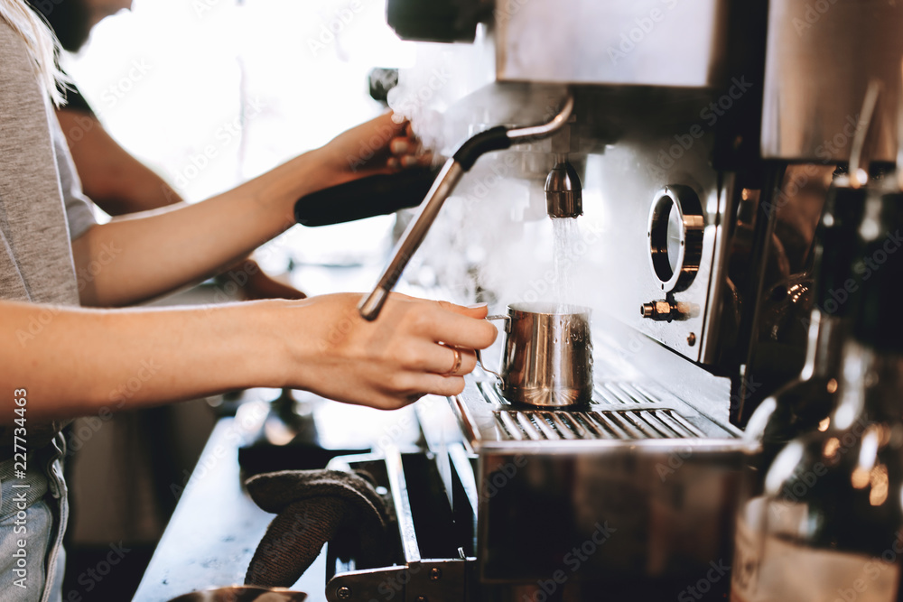 A modern expensive coffee machine is shown in work in  modern cozy coffee shop.