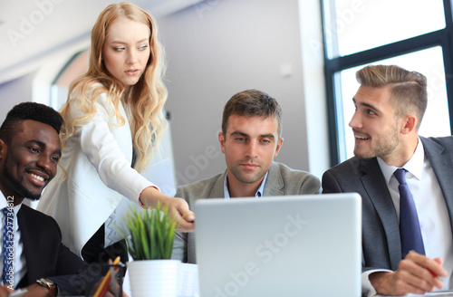 Startup business team on meeting in modern bright office interior and working on laptop.