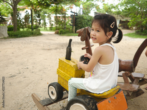 Wallpaper Mural Asian kid sitting on wooden car toy while playing in playground with happy smile face. Torontodigital.ca
