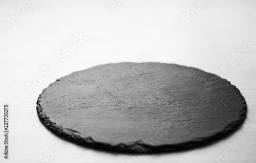 Black slate plate for food in cafe. Empty stone dish with space for product placement