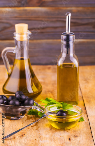 Olive Oil. Bottle of Virgin Olive Oil. Olives and Healthy Olive oil bottles and cup with parsley on old wooden table.