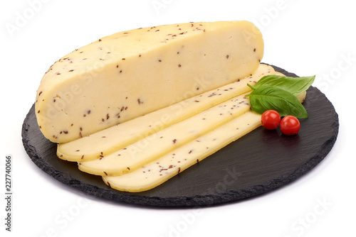 Sliced fresh Feta Cheese with cumin seeds on a slate shale plate, isolated on a white background. photo