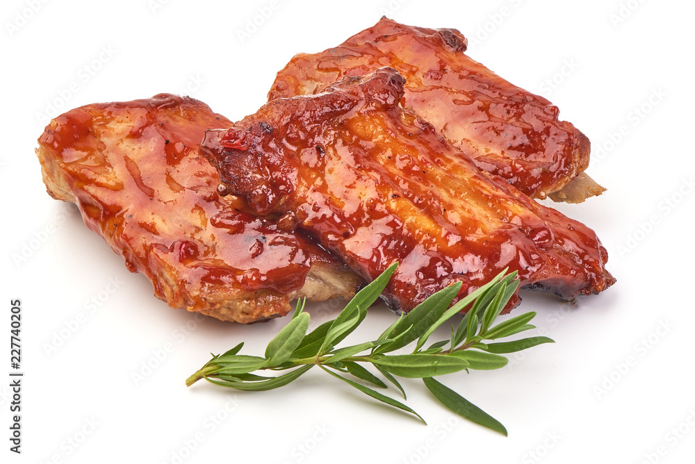 Delicious spicy marinated ribs in a bbq or tomato sauce with herbs, isolated on a white background. Close-up.
