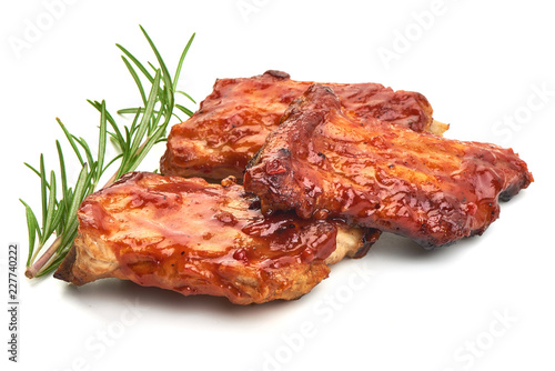 Delicious spicy marinated ribs in a bbq or tomato sauce with herbs, isolated on a white background. Close-up.