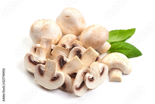 Sliced champignons with basil leaves, close-up, isolated on white background.