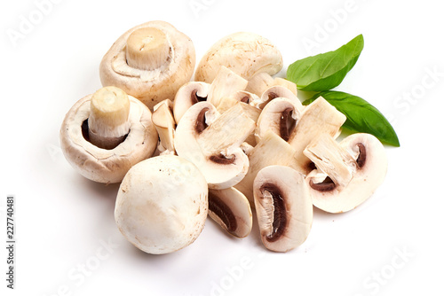 Sliced champignons with basil leaves, close-up, isolated on white background.