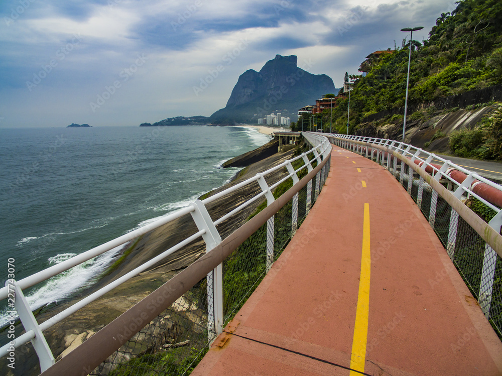Highway by the sea. Wonderful road and bike path. Bicycle and road track and next to the blue sea in the city of Rio de Janeiro. Tim Maia bike path on Niemeyer Avenue, Rio de Janeiro, Brazil.