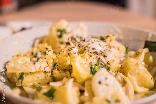 Close up of a potato salad with mayonnaise, onion, parsley and oregano