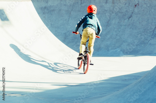 boy pedaling his bicycle in a bmx park