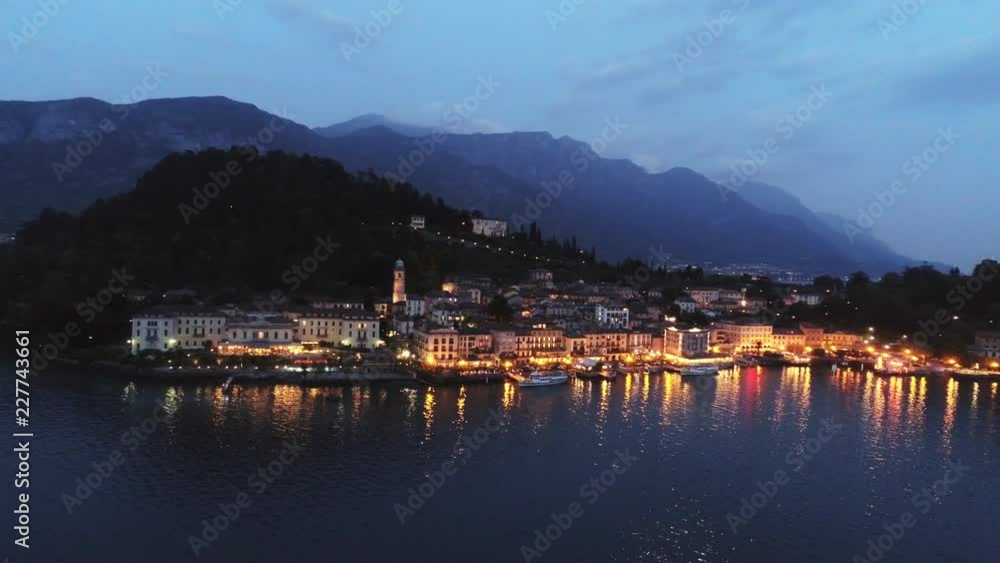 Aerial view illuminated town placed on cape lanterns light reflecting in water motion panoram along city over lake. Bellagio, Italy Aerial view illuminated town placed on cape lanterns light reflecting in water motion panoram along city over lake. Bellagio, Italy