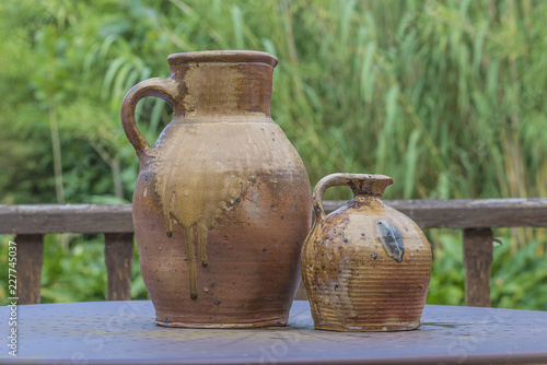Two vintage clay jugs on the table outdoors