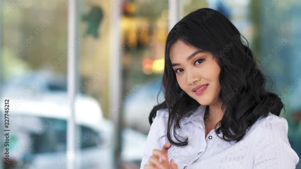 Medium close-up shot portrait of smiling Asian young business woman looking at camera Medium close-up shot portrait of smiling Asian young business woman looking at camera
