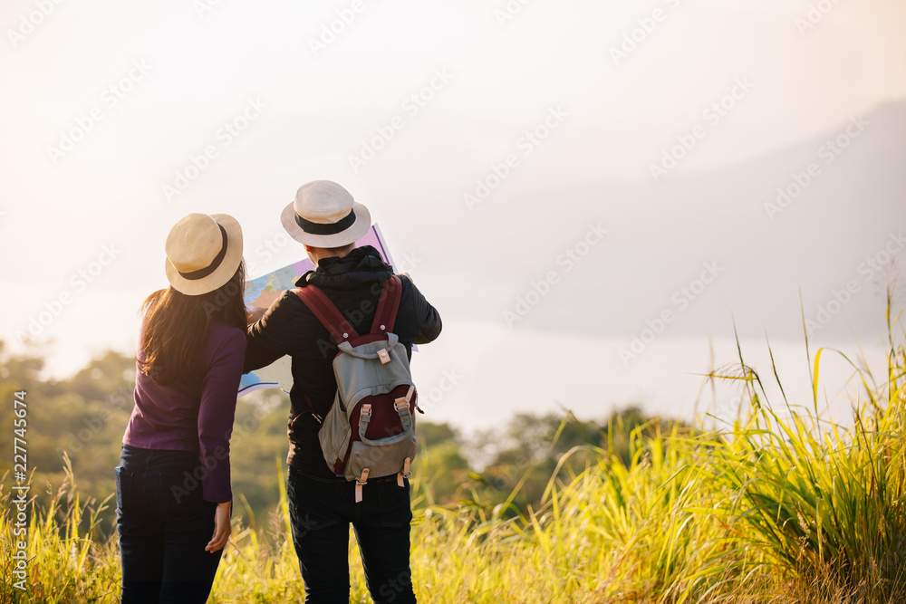 Two Young Tourists hiking in a nature climbing hill or mountain - man and woman trekking 