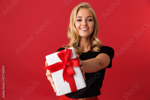 Portrait of a happy young woman isolated over red