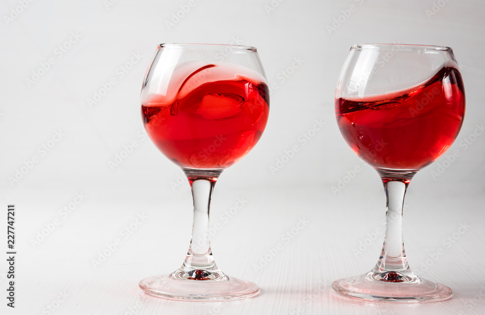 Two glasses with red juice, wine with different splashes Two glasses with red juice, wine with different splashes