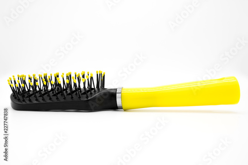 Black plastic comb with a yellow handle