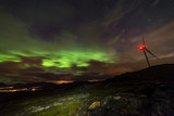 Aurora borealis being a wind turbine generator on top of a hill