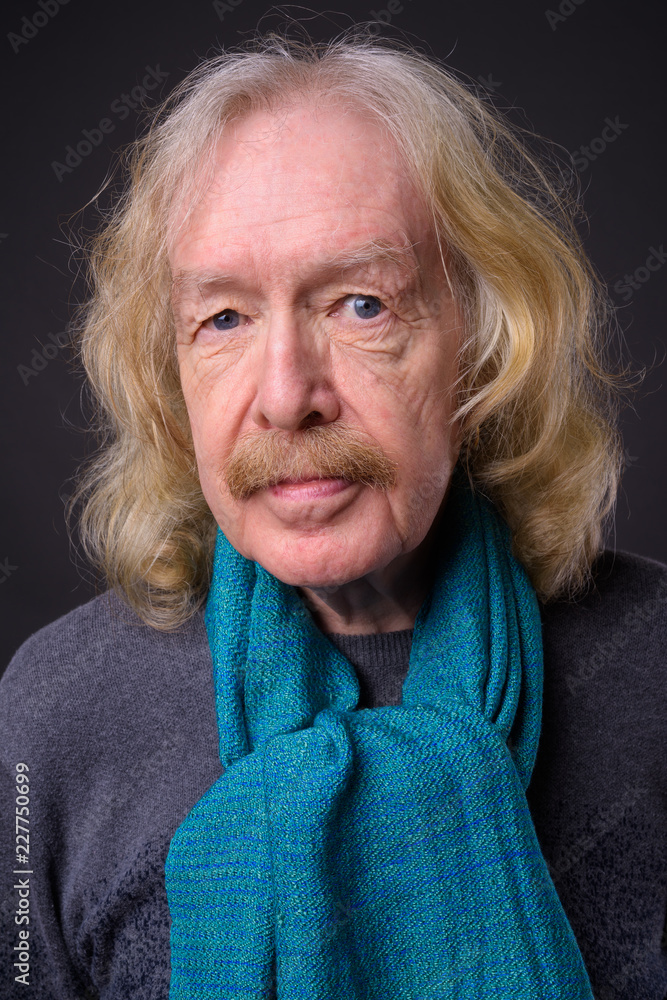 Senior man with mustache against gray background Senior man with mustache against gray background