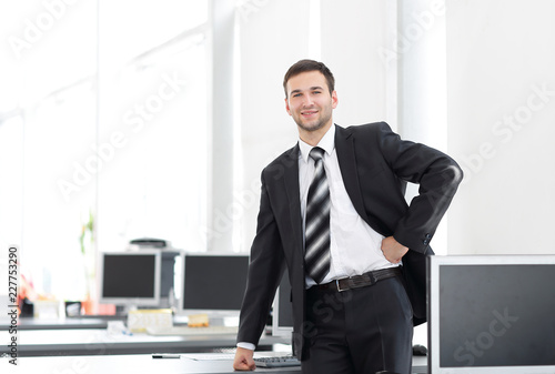 senior Manager standing in a modern office before the start of the working day