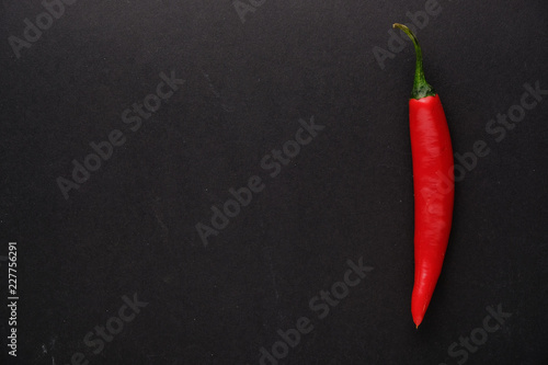Red hot chili pepper on black background top view with copy space