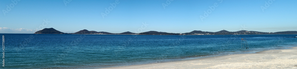Panorama of a white sand beach and mountains