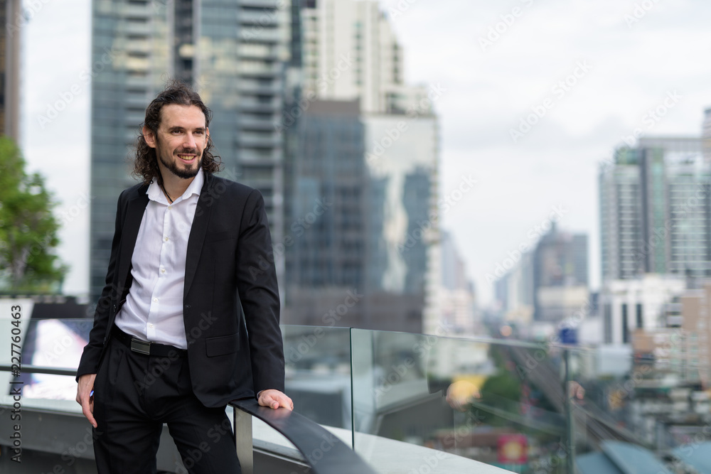 Handsome businessman against view of the city in Bangkok, Thaila