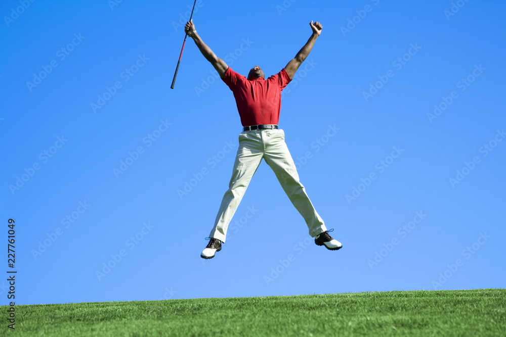 happy young man jumping on green grass playing golf happy young man jumping on green grass playing golf