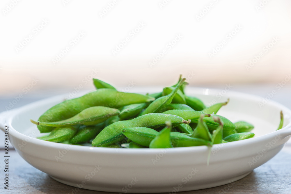 closeup view Soybean pods on white dish in the nature background closeup view Soybean pods on white dish in the nature background
