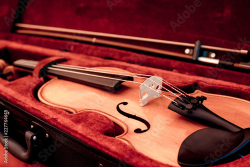 Violin and bow in dark red case. Close up view of a violin