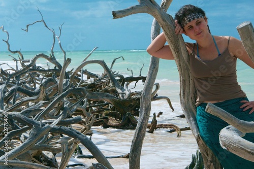 waiting young woman on beach Playa Jutías in Cuba full of driftwood