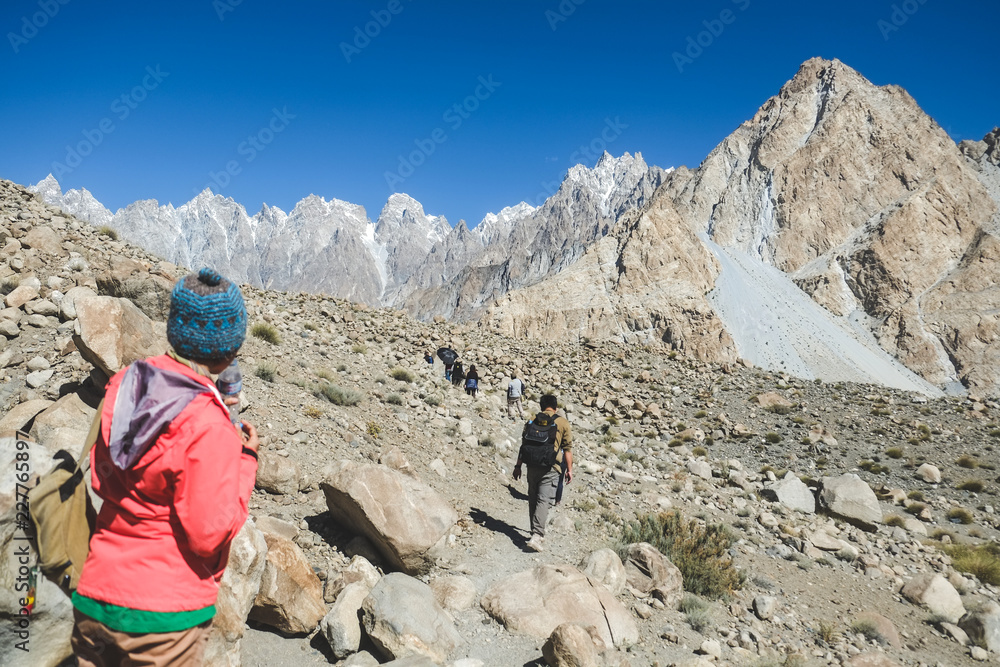 Trekkers walking along the track in Passu, Gilgit Baltistan, Pakistan. Trekkers walking along the track in Passu, Gilgit Baltistan, Pakistan.