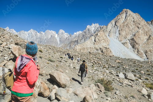 Trekkers walking along the track in Passu, Gilgit Baltistan, Pakistan.