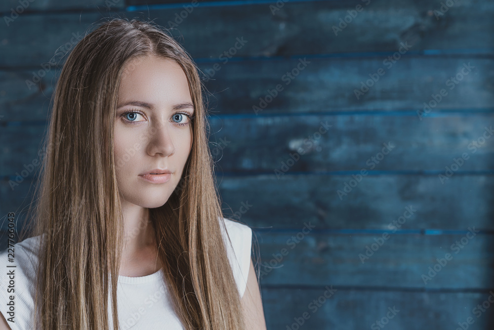 Fototapeta premium portrait of a serious girl on a blue background